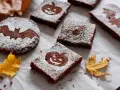 Deliciosos brownie halloween con calabazas y murciélagos, espolvoreados con azúcar glas.