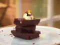 Delicioso brownie airfryer apilado, coronado con helado y pétalos.