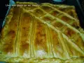Empanada marinera dorada y crujiente, lista para disfrutar. Su masa cubierta con un enrejado perfecto promete un sabor delicioso.