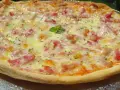 Pizza con masa hecha en Thermomix, cubierta de queso fundido, trocitos de bacon y hierbas aromáticas.