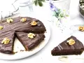 Delicioso pastel alemán de chocolate cubierto con glaseado brillante y nueces. Una rebanada ya servida.