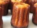 Un grupo de canelés de Bordeaux, con su característica corteza dorada y acanalada, listos para ser disfrutados.
