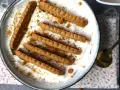 Delicioso postre con yogur natural sin horno, decorado con galletas crujientes y migas.