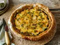 Delicioso quiche de espinacas con patatas laminadas y hierbas frescas, listo para servir.