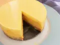 Tarta mango cremosa, con una porción retirada, sobre plato azul claro.