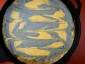 Pastel de maíz con remolinos grises y amarillos en una sartén de hierro fundido.