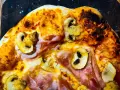 Pizza masa madre con champiñones y jamón, con bordes dorados y burbujas de queso fundido.