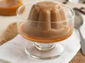 Deliciosa panna cotta de café, con un suave caramelo líquido, servida en copa de cristal.