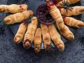 Galletas con forma de dedos, decoradas con almendras como uñas y mermelada roja simulando sangre. Un espeluznante postre de Halloween.