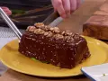 Un delicioso bizcocho de plátano cubierto de chocolate brillante y nueces, listo para ser cortado.