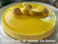Tarta de queso y mango sin horno, decorada con trozos de manzana, naranja y galletas. ¡Un postre refrescante y delicioso!