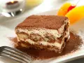 Delicioso tiramisú con mascarpone, espolvoreado con cacao. Una porción perfecta para disfrutar de esta clásica receta italiana.