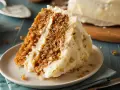 Rebanada de tarta de zanahoria casera con glaseado cremoso y nueces. ¡Una delicia para tu próxima receta!