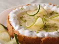 Delicioso key lime pie con merengue, rodajas de lima y ralladura verde.