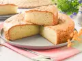 Bizcocho sin huevo esponjoso y dorado, cortado en porciones sobre un plato gris. Ideal para desayunos o meriendas.