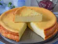 Tarta de queso y limón al horno, dorada y esponjosa, con una porción servida.