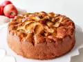 Bizcocho de manzana esponjoso, dorado y brillante, con trozos de manzana caramelizada en la superficie. ¡Perfecto para tu próxima receta!