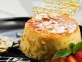 Delicioso postre de piña y leche condensada, cubierto de caramelo y decorado con almendras y fresas.
