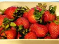 Un tazón lleno de jugosas fresas rojas, listas para ser bañadas en dulce leche condensada.
