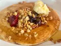 Deliciosos crepes con harina de almendras, cubiertos con granola, frutos rojos, arándanos y una porción de mantequilla.