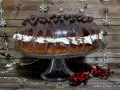 Un delicioso roscon de reyes chocolate, cubierto de glaseado y bolitas de chocolate, con crema y decoraciones navideñas.