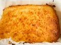 Un delicioso blondie dessert recién horneado, dorado y crujiente, listo para ser cortado y disfrutado.