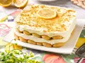 Delicioso tiramisú de limón, con capas de bizcochos y crema, coronado con una rodaja de limón y ralladura dorada.
