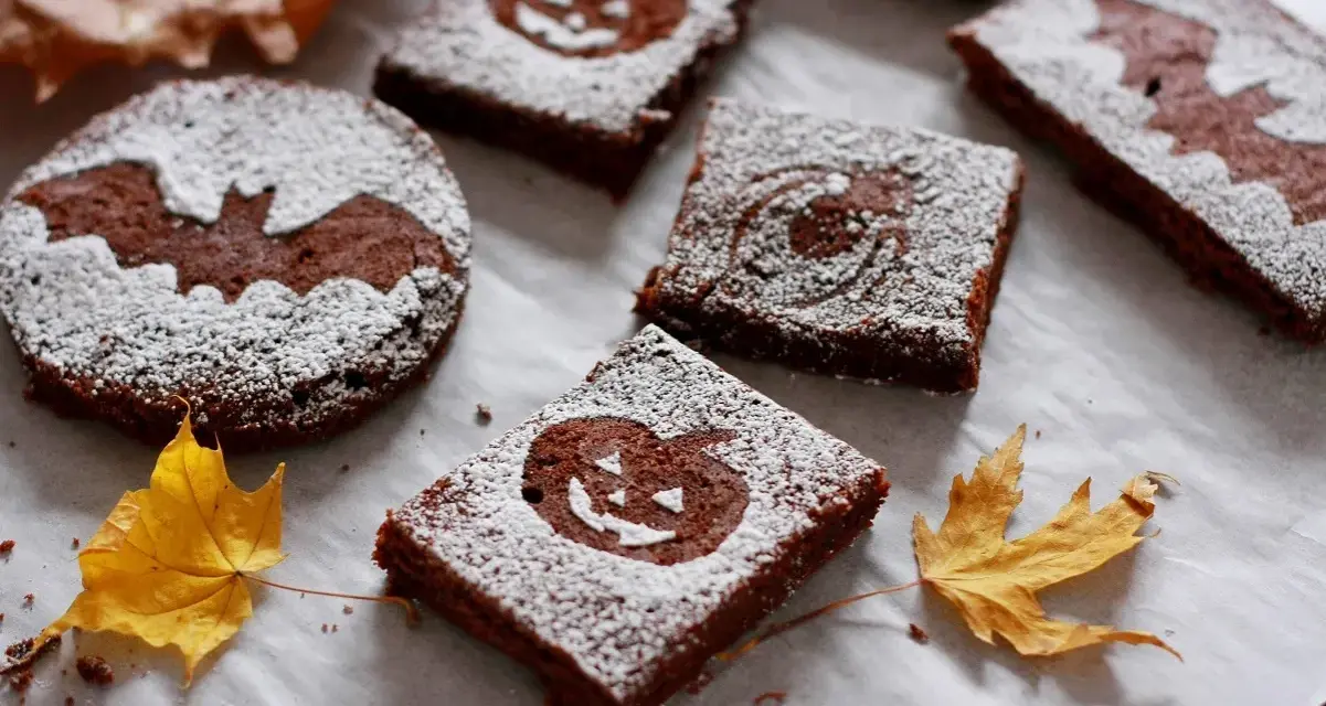 Deliciosos brownie halloween con calabazas y murciélagos, espolvoreados con azúcar glas.