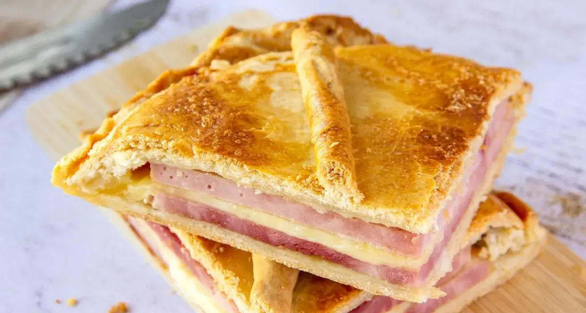 Dos porciones de empanadillas de jamón y queso, con capas doradas de masa y relleno generoso, listas para disfrutar.