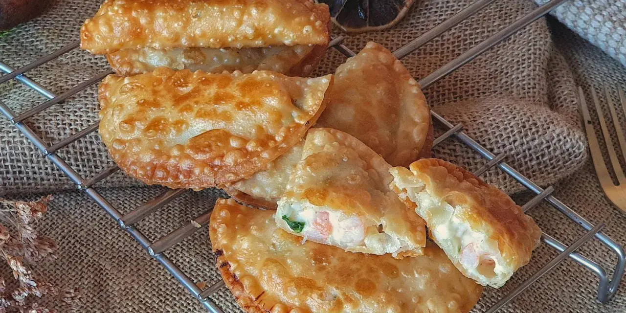 Empanadillas de gambas doradas y crujientes, rellenas de marisco y cremosidad, listas para disfrutar.