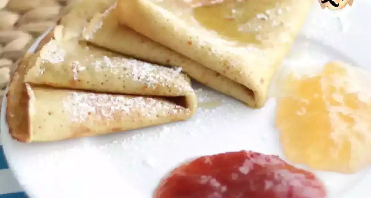 Deliciosos crepes sin gluten, espolvoreados con azúcar glas y acompañados de mermelada de fresa y melocotón.