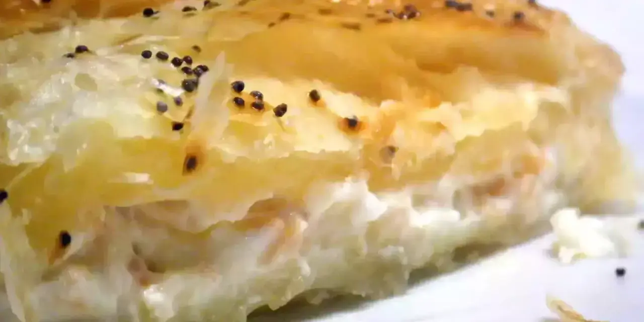 Un trozo de hojaldre de salmón y philadelphia, con semillas de amapola espolvoreadas.