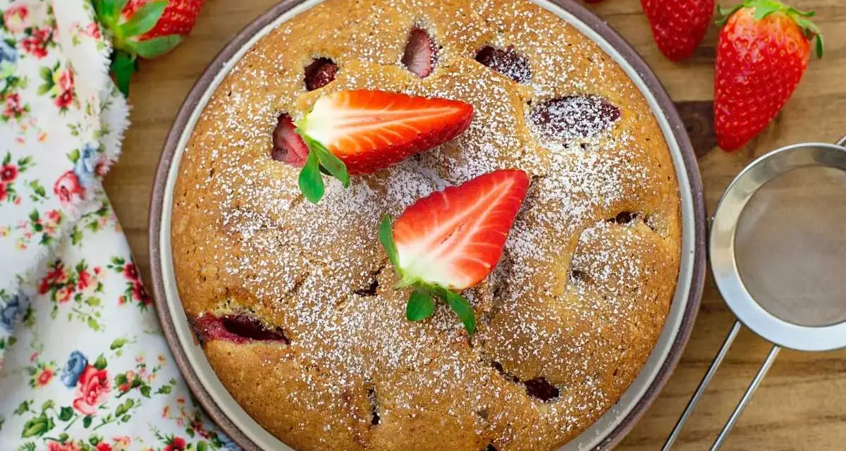 Delicioso bizcocho de fresa, espolvoreado con azúcar glas y decorado con fresas frescas. Un postre casero perfecto.