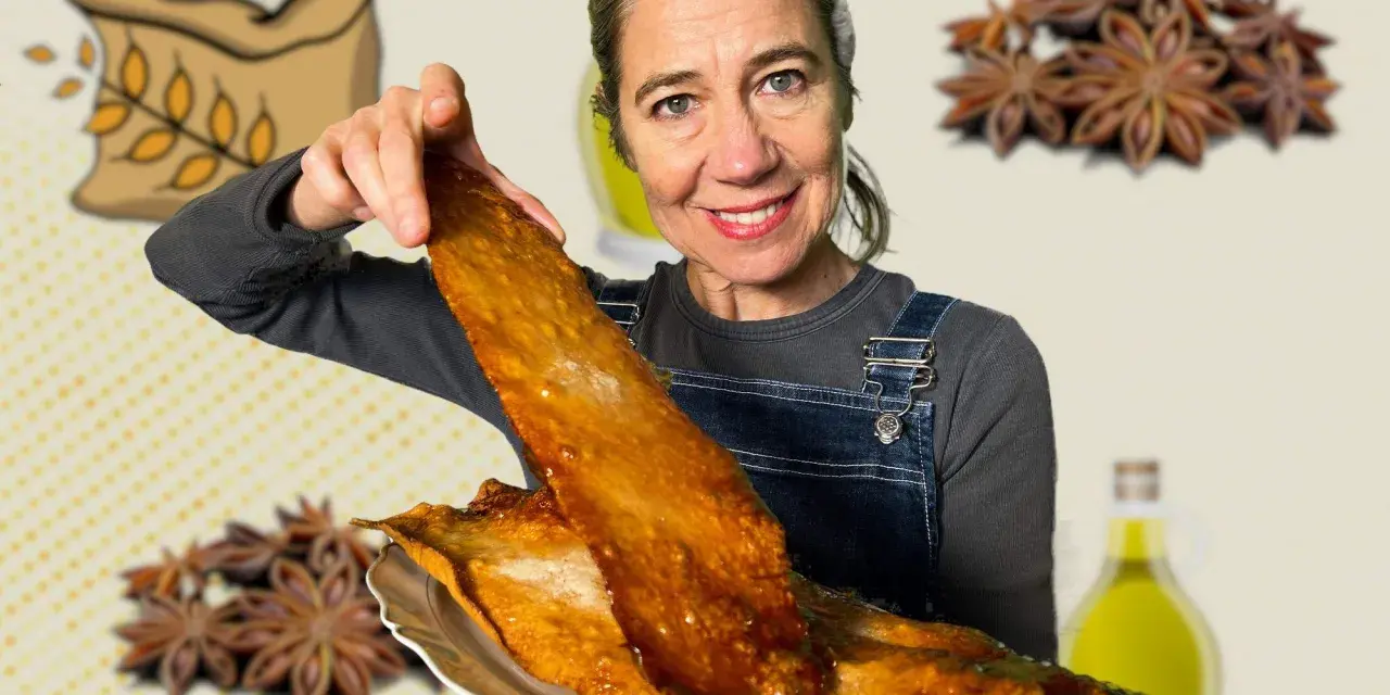 Mujer sonriente muestra una coca de vidre dorada, con ingredientes como harina, anís y aceite de oliva de fondo.