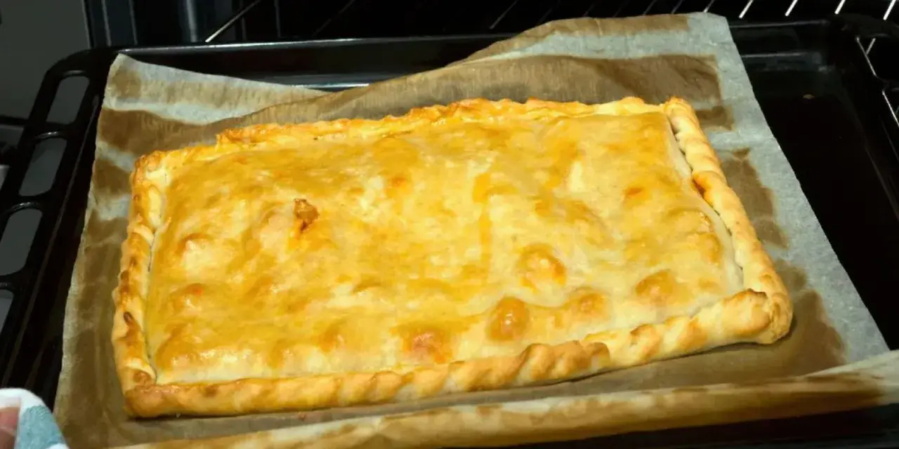 Empanada de zamburiñas recién horneada, dorada y lista para disfrutar.