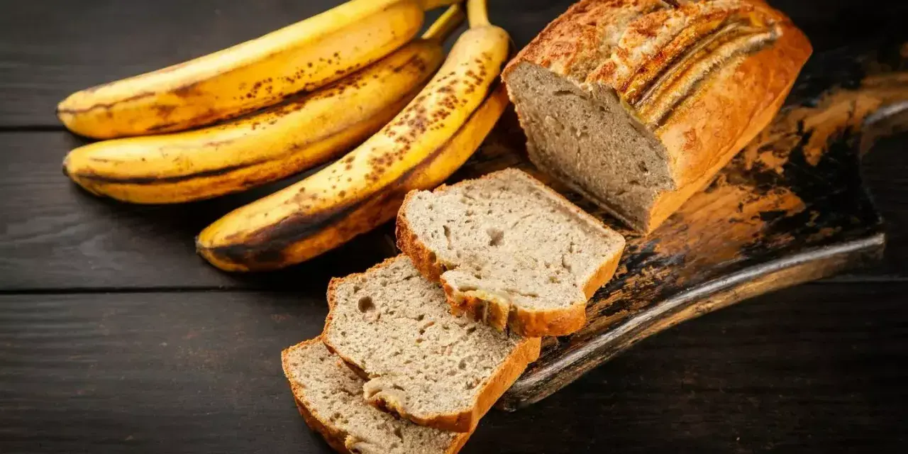 Plátanos maduros junto a un delicioso banana bread recién horneado, con rebanadas listas para disfrutar.
