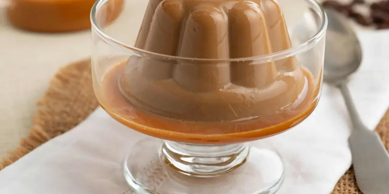 Deliciosa panna cotta de café, con un suave caramelo líquido, servida en copa de cristal.