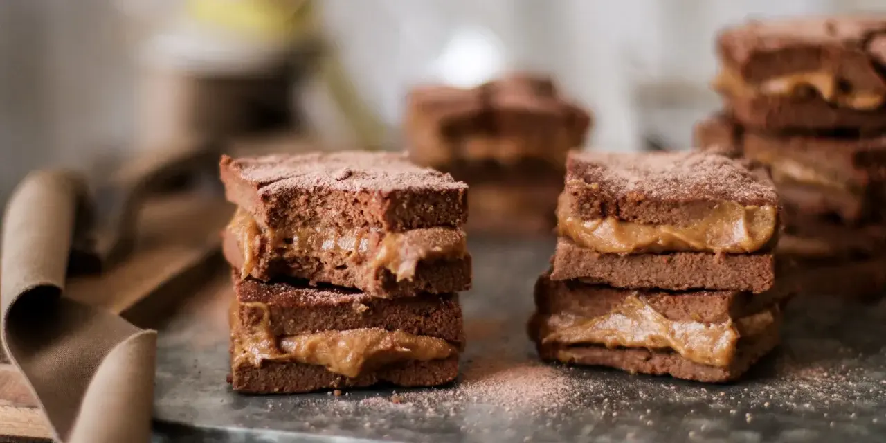 Deliciosos brownie con dátiles, apilados y espolvoreados con cacao. Un dulce placer que te hará soñar.