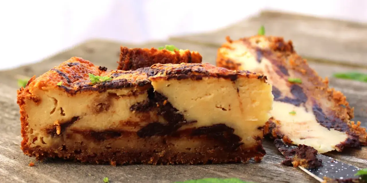 Tarta de queso con chocolate, con trozos de chocolate oscuro y una base crujiente. Perfecta para los amantes del dulce.