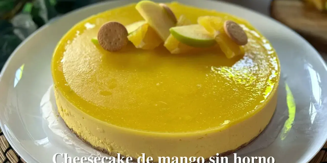 Tarta de queso y mango sin horno, decorada con trozos de manzana, naranja y galletas. ¡Un postre refrescante y delicioso!