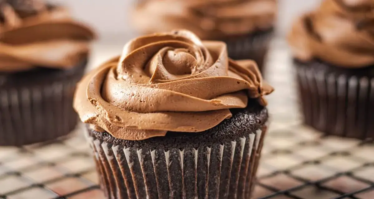 Deliciosas magdalenas sin huevo con glaseado de chocolate cremoso, decoradas como una rosa.