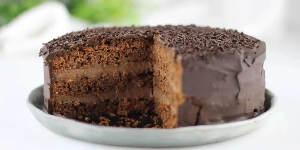 Tarta vegana de chocolate con cobertura brillante y virutas de chocolate. ¡Una delicia para los amantes del cacao!
