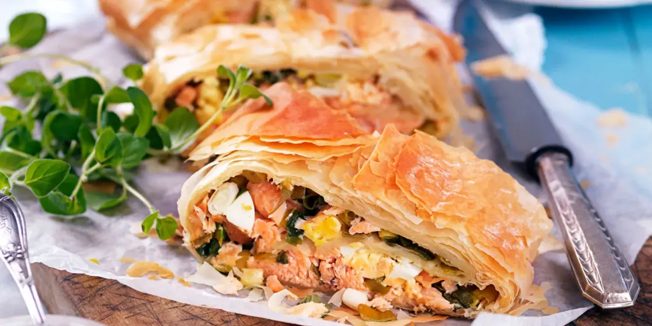 Delicioso salmón con hojaldre y puerros, un plato crujiente y lleno de sabor.