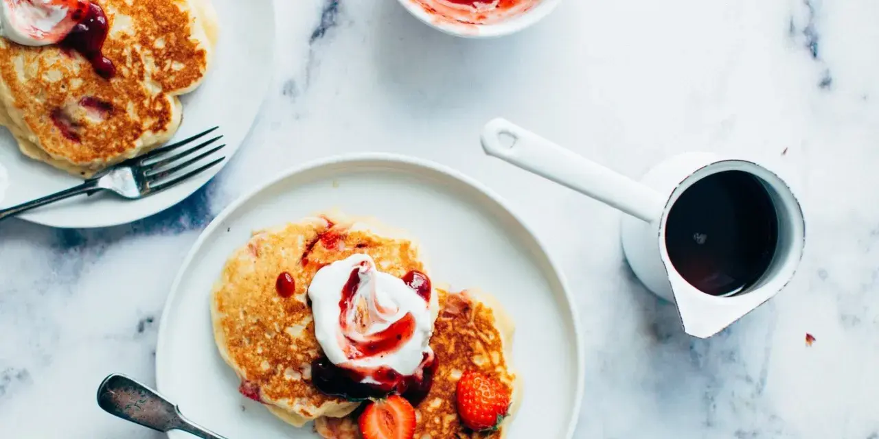 Deliciosas tortitas con fresas y nata, listas para servir. Aprende como hacer tortitas perfectas para el desayuno.