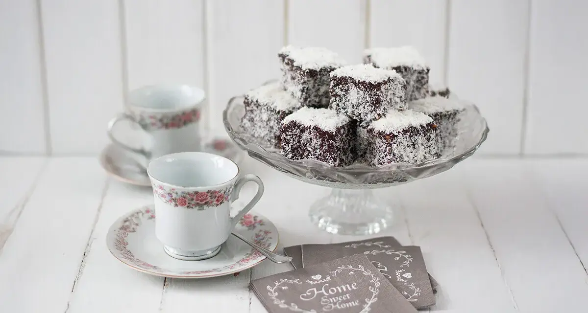Deliciosos lamington cake cubiertos de coco, listos para disfrutar con café.