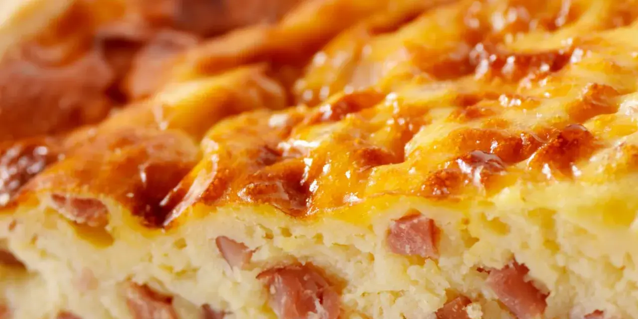 Primer plano de una deliciosa quiche Lorraine, con trozos de bacon y una dorada capa superior. ¡Perfecta para tu próxima receta!