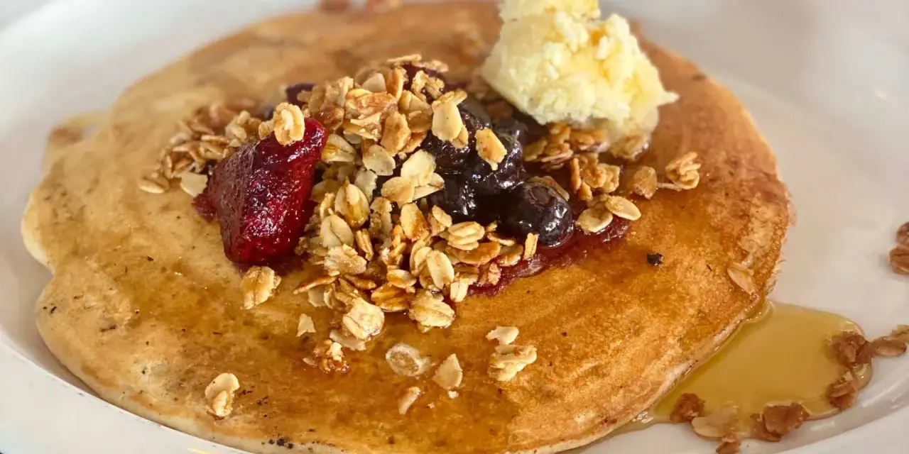 Deliciosos crepes con harina de almendras, cubiertos con granola, frutos rojos, arándanos y una porción de mantequilla.