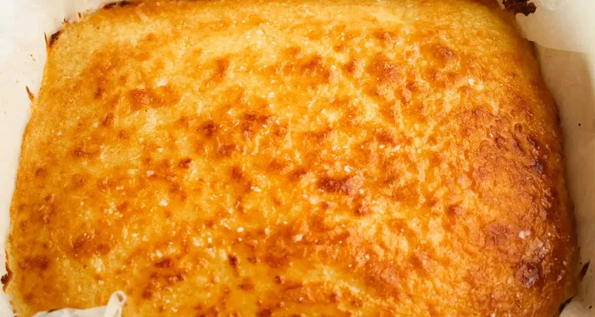 Un delicioso blondie dessert recién horneado, dorado y crujiente, listo para ser cortado y disfrutado.