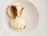Dos bolas de helado de tiramisú con un toque de cacao en polvo en un cuenco blanco.