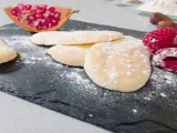 Bizcochos soletilla espolvoreados con azúcar glas, acompañados de frambuesas y granada.